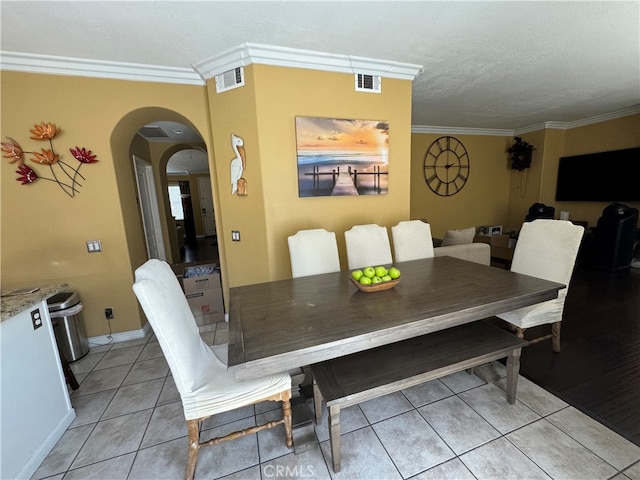 tiled dining area featuring crown molding