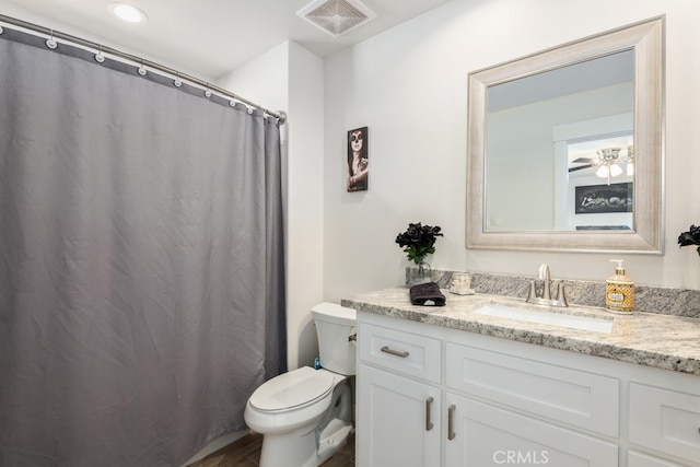 bathroom with ceiling fan, vanity, hardwood / wood-style flooring, a shower with curtain, and toilet