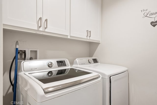 washroom featuring washing machine and dryer and cabinets