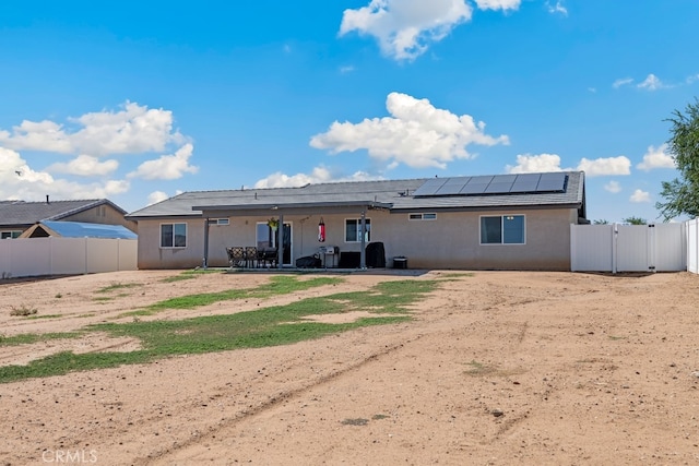 back of house with a patio and solar panels