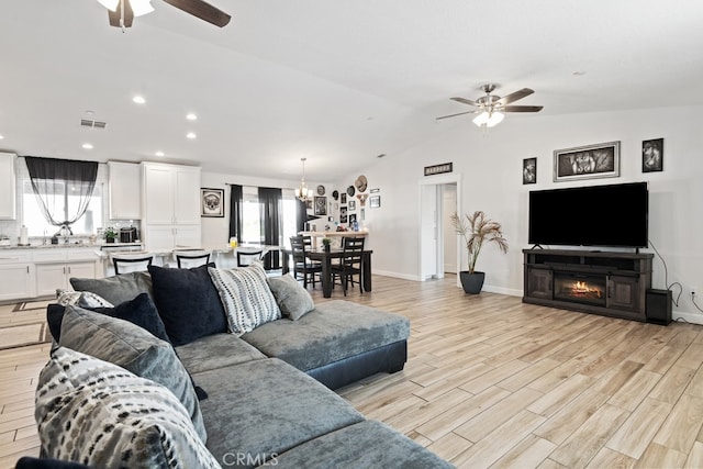 living room featuring ceiling fan, lofted ceiling, and a healthy amount of sunlight