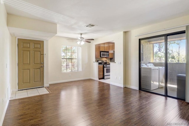 unfurnished living room featuring light wood-type flooring, washer and clothes dryer, and ceiling fan