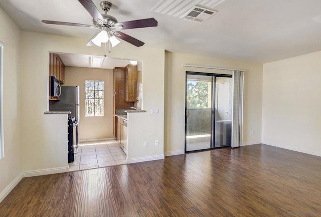 kitchen with stainless steel appliances, plenty of natural light, and light hardwood / wood-style floors