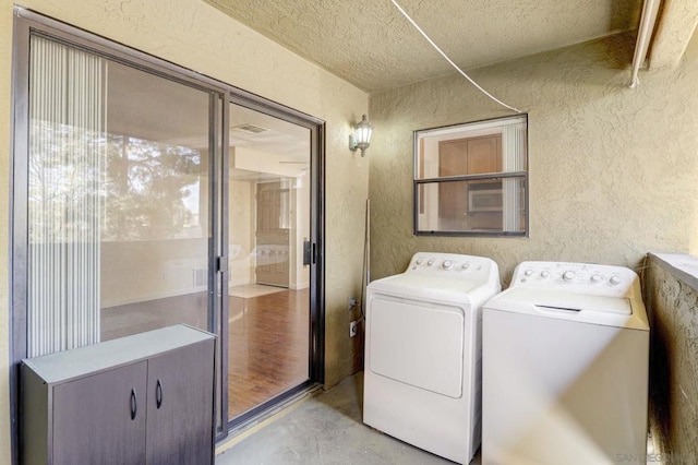 washroom featuring a textured ceiling and washer and dryer