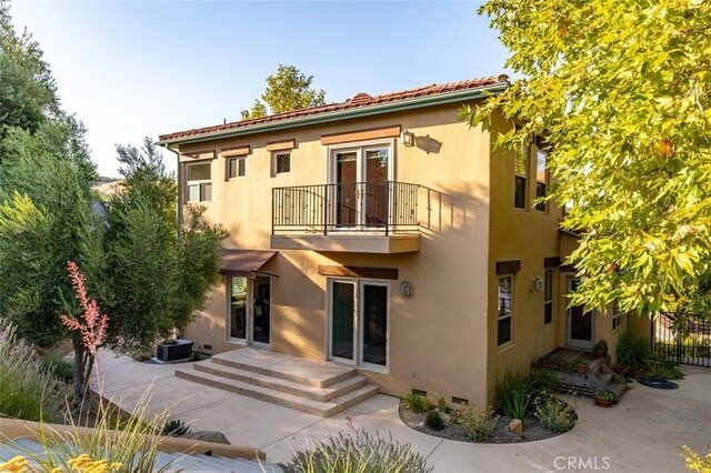 rear view of house featuring central AC, a patio area, and a balcony