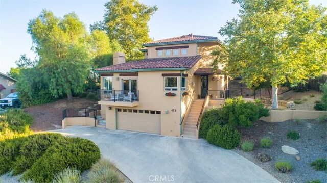 mediterranean / spanish home featuring a balcony and a garage