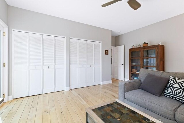 living room with ceiling fan and light hardwood / wood-style flooring