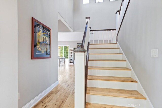 stairs featuring hardwood / wood-style floors and a towering ceiling