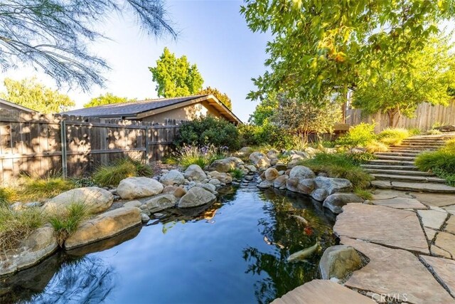 view of pool with a small pond