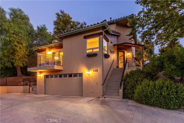 view of front of home featuring a balcony and a garage