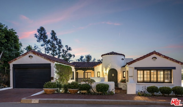 mediterranean / spanish home featuring a garage