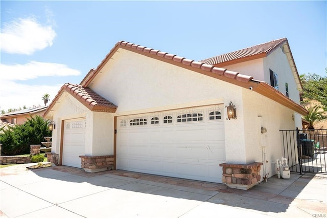 view of side of property featuring a garage and central AC