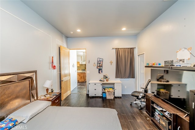 bedroom with connected bathroom and dark hardwood / wood-style floors