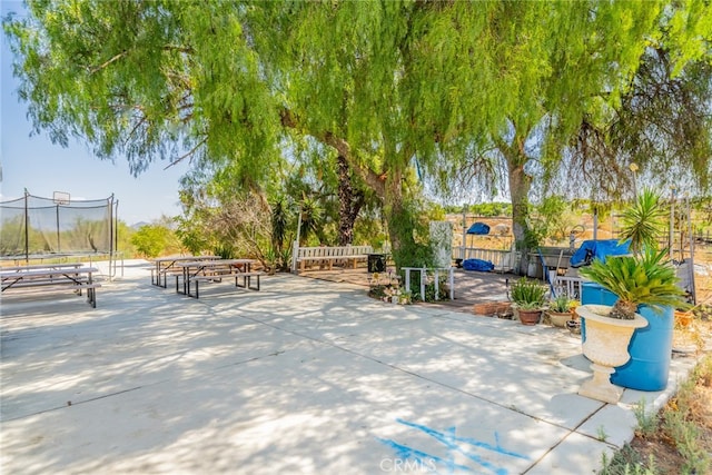 view of home's community with a trampoline and a patio area