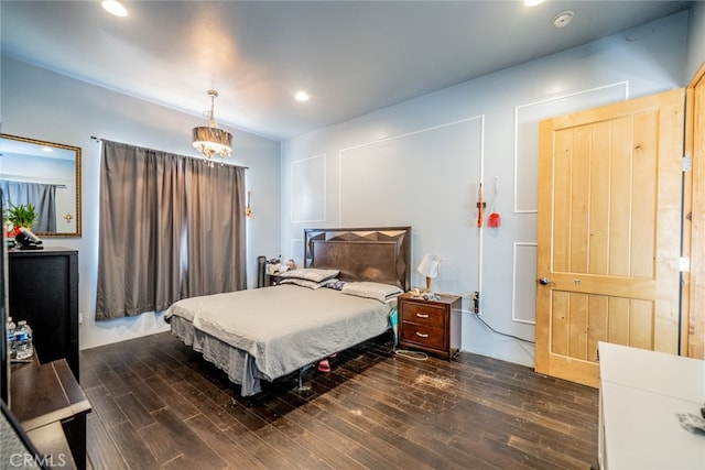 bedroom featuring a chandelier and dark wood-type flooring