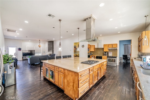 kitchen with pendant lighting, appliances with stainless steel finishes, dark wood-type flooring, and light stone countertops