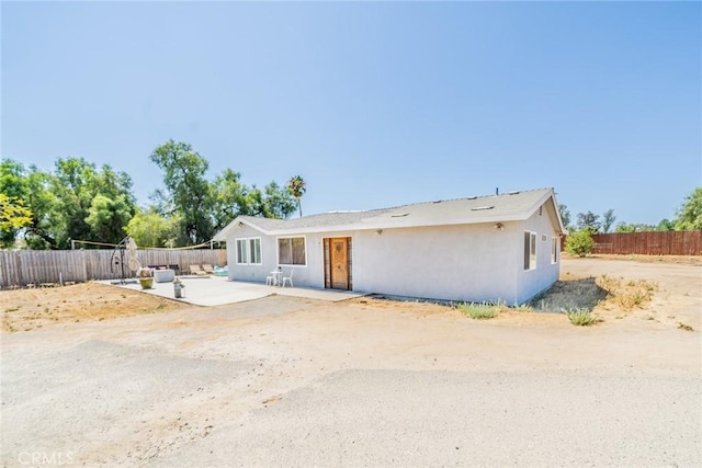 ranch-style home with a patio area, fence, and stucco siding