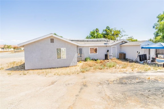 single story home with cooling unit and stucco siding