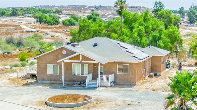 view of front of house with solar panels and stucco siding