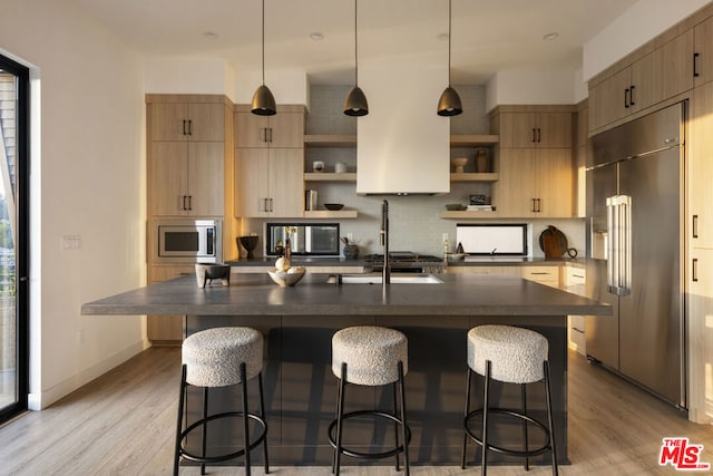 kitchen with built in appliances, plenty of natural light, and light wood-type flooring