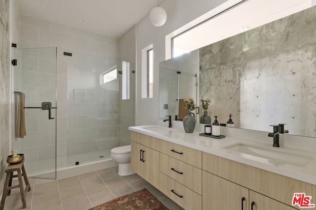 bathroom with tile patterned flooring, vanity, toilet, and walk in shower