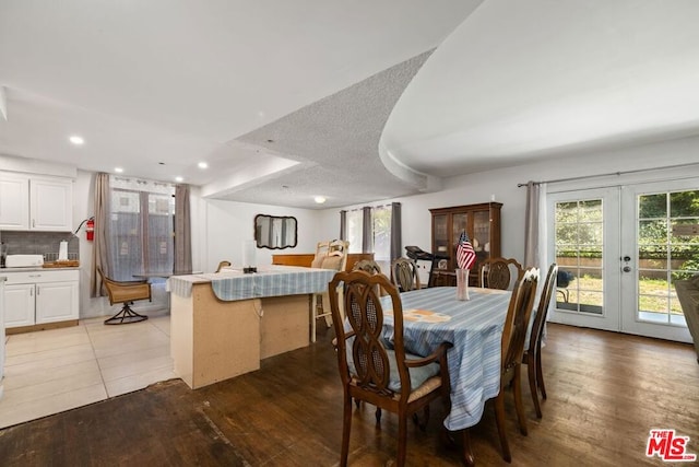 dining space with hardwood / wood-style flooring, a textured ceiling, and french doors