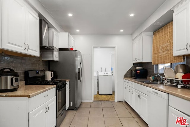 kitchen with wall chimney range hood, sink, black appliances, independent washer and dryer, and white cabinetry