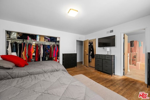 bedroom featuring connected bathroom, a closet, and hardwood / wood-style floors