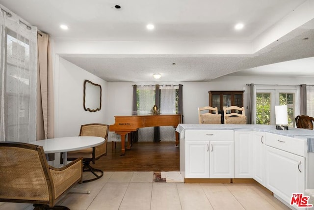 kitchen featuring light wood-type flooring, white cabinetry, and kitchen peninsula