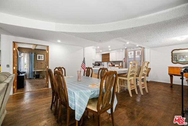 dining area featuring dark hardwood / wood-style floors and a textured ceiling