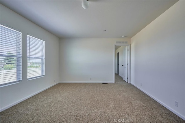 unfurnished room featuring light carpet