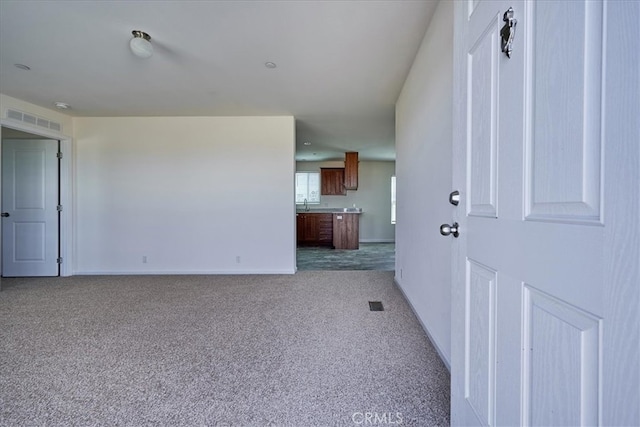 unfurnished living room featuring sink and light colored carpet