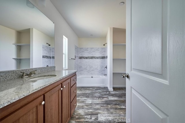 bathroom featuring hardwood / wood-style floors, vanity, and tiled shower / bath