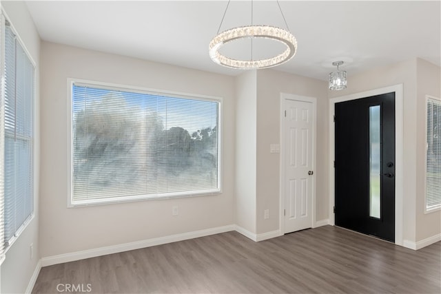 foyer with hardwood / wood-style floors and a chandelier