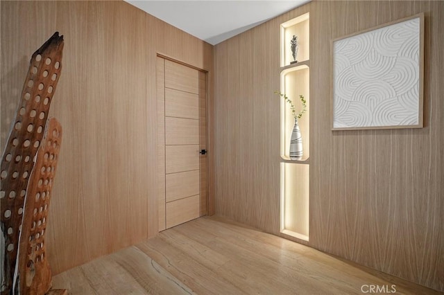 interior space featuring wooden walls and light hardwood / wood-style flooring