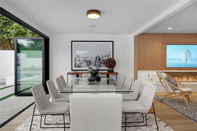 dining area with light hardwood / wood-style floors and a fireplace