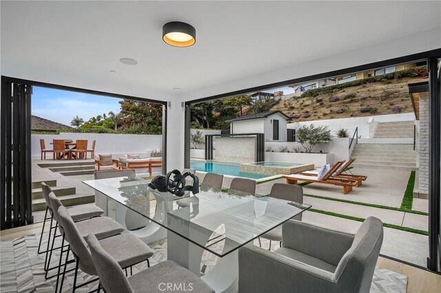 interior space featuring an outdoor living space and a swimming pool with hot tub