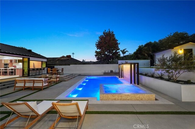 pool at dusk featuring a patio