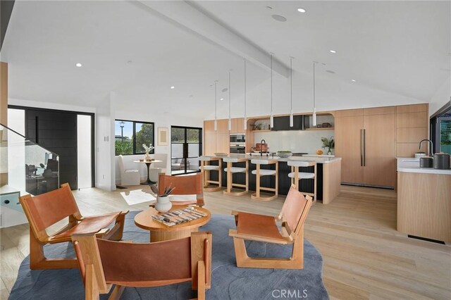 living room with light wood-type flooring, beam ceiling, and high vaulted ceiling