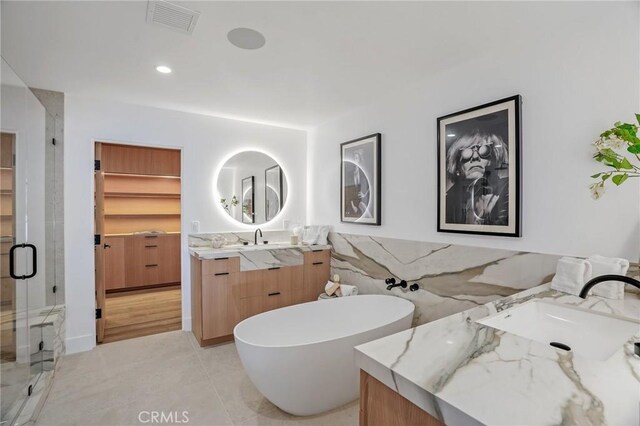 bathroom featuring independent shower and bath, tile patterned flooring, and vanity