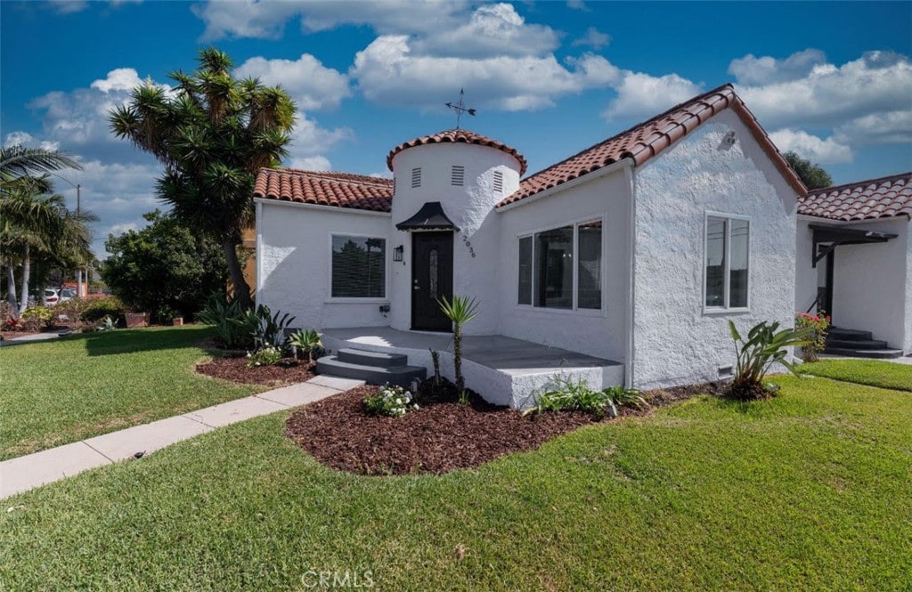 mediterranean / spanish-style home with a front yard