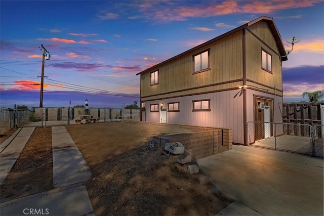 property exterior at dusk featuring a patio area