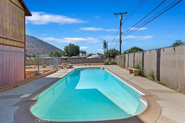 view of swimming pool featuring a mountain view and a patio area