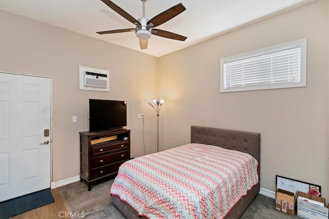 bedroom with ceiling fan, an AC wall unit, and dark colored carpet