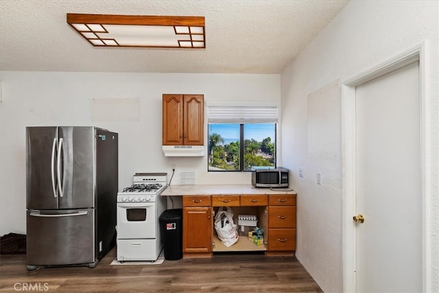 kitchen with dark wood-type flooring, stainless steel appliances, and a textured ceiling