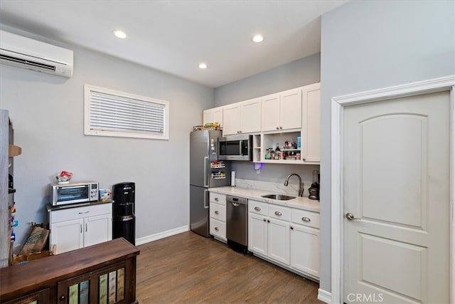 kitchen featuring sink, dark hardwood / wood-style flooring, stainless steel appliances, white cabinets, and a wall mounted AC