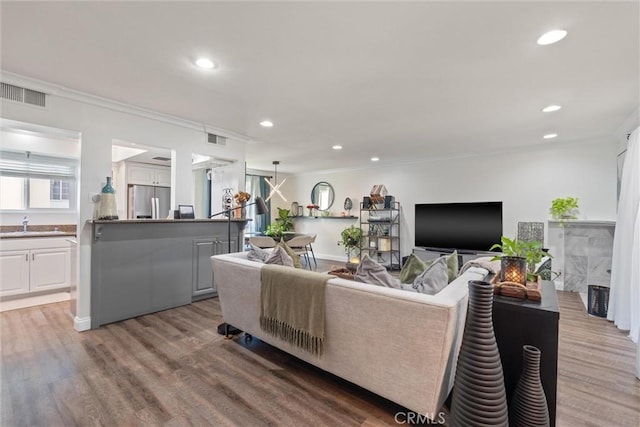 living room with crown molding and hardwood / wood-style floors