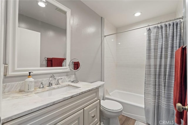 full bathroom featuring hardwood / wood-style floors, shower / bath combo, toilet, and vanity