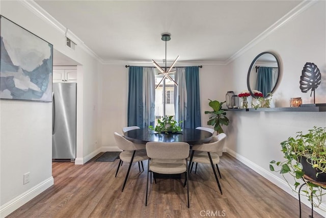 dining space featuring hardwood / wood-style floors, an inviting chandelier, and ornamental molding