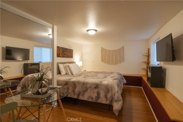 bedroom with a textured ceiling and hardwood / wood-style flooring